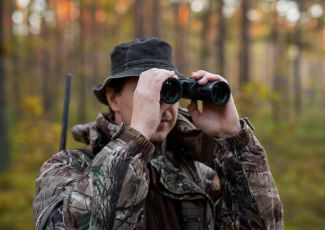 hunter looks through binoculars